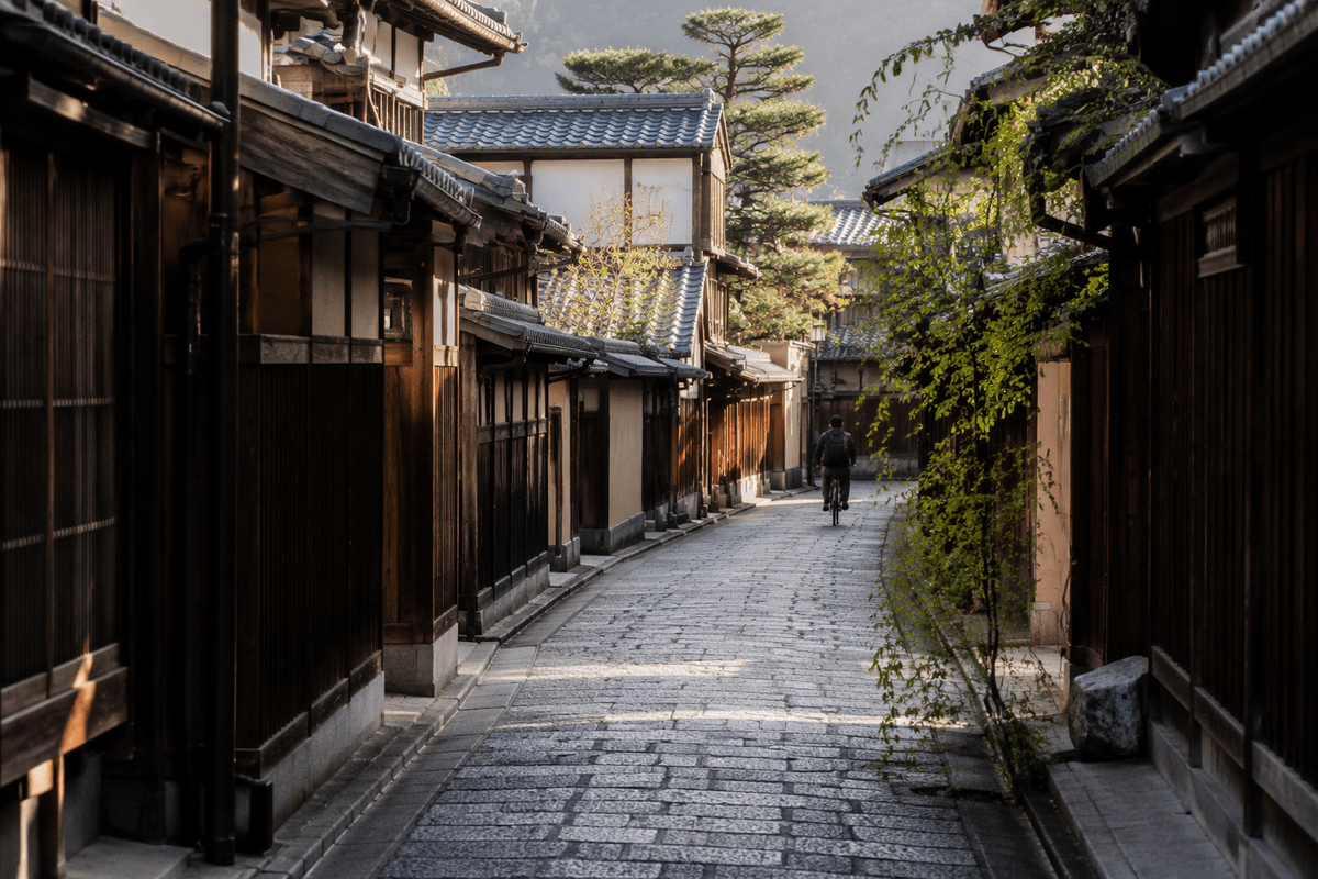 A calm stone-paved side street lined with wooden buildings in Higashiyama.